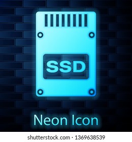 Glowing neon SSD card icon isolated on brick wall background. Solid state drive sign. Storage disk symbol. Vector Illustration