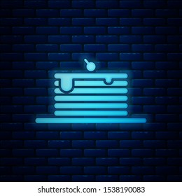 Glowing neon Stack of pancakes icon isolated on brick wall background. Baking with syrup and cherry. Breakfast concept.  Vector Illustration