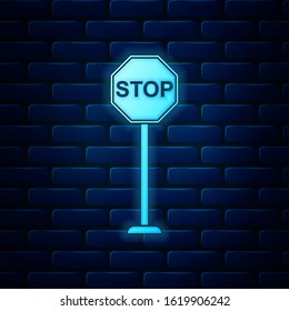 Glowing neon Stop icon isolated on brick wall background. Traffic regulatory warning stop symbol.  Vector Illustration
