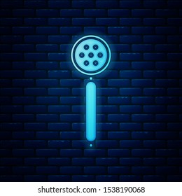 Glowing neon Strainer spoon icon isolated on brick wall background.  Vector Illustration