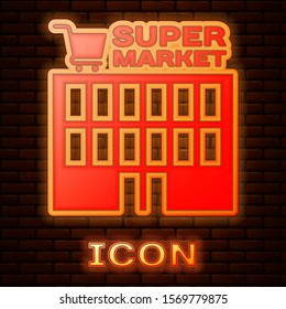 Glowing neon Supermarket building with shopping cart icon isolated on brick wall background. Shop or store. Mall building.  Vector Illustration
