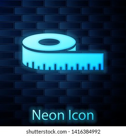 Glowing neon Tape measure icon isolated on brick wall background. Measuring tape.  Vector Illustration