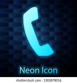 Glowing neon Telephone handset icon isolated on brick wall background. Phone sign. Vector Illustration