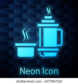 Glowing neon Thermos container icon isolated on brick wall background. Thermo flask icon. Camping and hiking equipment.  Vector Illustration