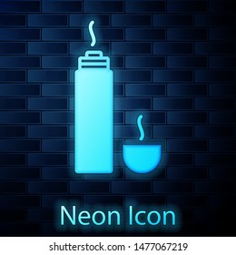 Glowing neon Thermos container icon isolated on brick wall background. Thermo flask icon. Camping and hiking equipment.  Vector Illustration