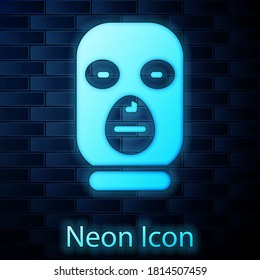 Glowing neon Thief mask icon isolated on brick wall background. Bandit mask, criminal man. Vector.