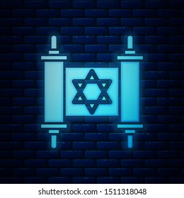 Glowing neon Torah scroll icon isolated on brick wall background. Jewish Torah in expanded form. Star of David symbol. Old parchment scroll.  Vector Illustration