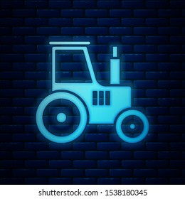 Glowing neon Tractor icon isolated on brick wall background.  Vector Illustration