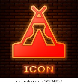Glowing neon Traditional indian teepee or wigwam icon isolated on brick wall background. Indian tent. Vector
