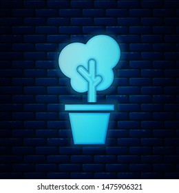Glowing neon Tree in pot icon isolated on brick wall background. Houseplant in pots. Natural decor for home and interior. Potted plant sign.  Vector Illustration