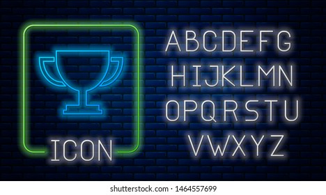 Glowing neon Trophy cup icon isolated on brick wall background. Award symbol. Champion cup icon. Neon light alphabet. Vector Illustration