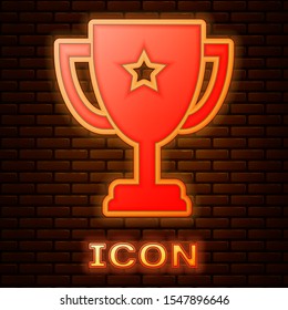 Glowing neon Trophy cup icon isolated on brick wall background. Award symbol. Champion cup icon.  Vector Illustration