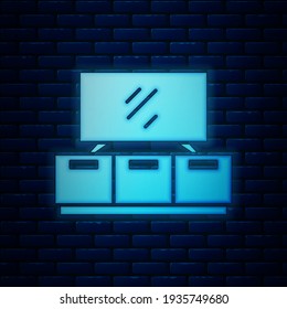 Icono del soporte de la mesa de neón brillante aislado en el fondo de la pared de ladrillo.  Vector