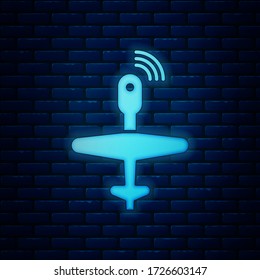 Glowing neon UAV Drone icon isolated on brick wall background. Military Unmanned aircraft spy.  Vector Illustration
