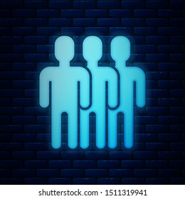 Glowing neon Users group icon isolated on brick wall background. Group of people icon. Business avatar symbol - users profile icon.  Vector Illustration
