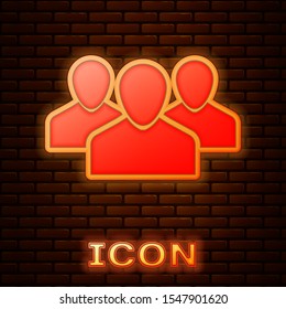 Glowing neon Users group icon isolated on brick wall background. Group of people icon. Business avatar symbol - users profile icon.  Vector Illustration
