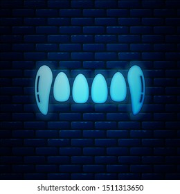 Glowing neon Vampire teeth icon isolated on brick wall background. Happy Halloween party.  Vector Illustration