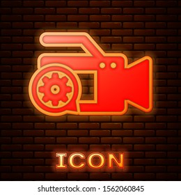 Glowing neon Video camera and gear icon isolated on brick wall background. Adjusting app, service concept, setting options, maintenance, repair, fixing.  Vector Illustration