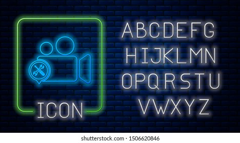 Glowing neon Video camera with screwdriver and wrench icon isolated on brick wall background.   Neon light alphabet. Vector Illustration
