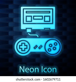 Glowing neon Video game console with joystick icon isolated on brick wall background.  Vector Illustration