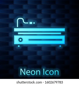 Glowing neon Video game console icon isolated on brick wall background.  Vector Illustration