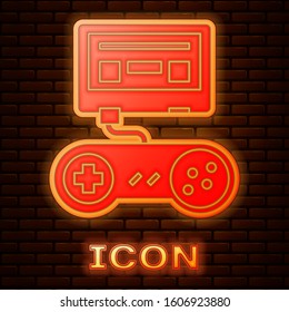 Glowing neon Video game console with joystick icon isolated on brick wall background.  Vector Illustration