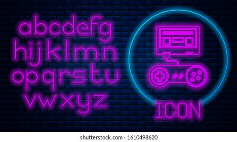 Glowing neon Video game console with joystick icon isolated on brick wall background. Neon light alphabet. Vector Illustration