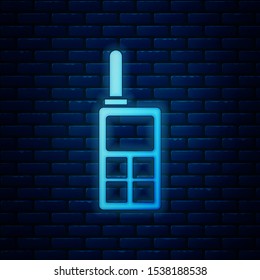 Glowing neon Walkie talkie icon isolated on brick wall background. Portable radio transmitter icon. Radio transceiver sign.  Vector Illustration