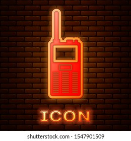 Glowing neon Walkie talkie icon isolated on brick wall background. Portable radio transmitter icon. Radio transceiver sign.  Vector Illustration