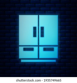 Glowing neon Wardrobe icon isolated on brick wall background.  Vector