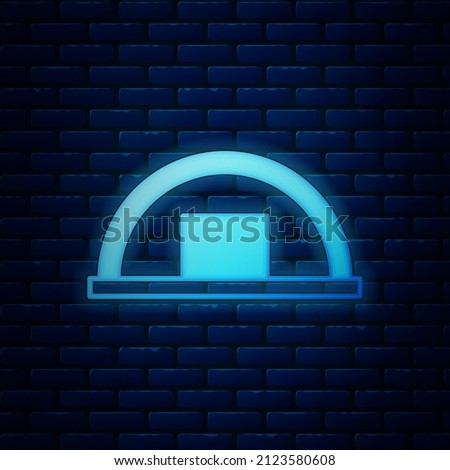 Glowing neon Warehouse icon isolated on brick wall background.  Vector