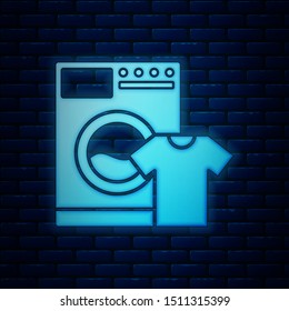 Glowing neon Washer and t-shirt icon isolated on brick wall background. Washing machine icon. Clothes washer, laundry machine. Home appliance symbol.  Vector Illustration