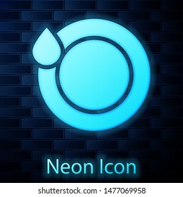 Glowing neon Washing dishes icon isolated on brick wall background. Plate and sponge. Cleaning dishes icon. Dishwasher sign. Clean tableware sign.  Vector Illustration