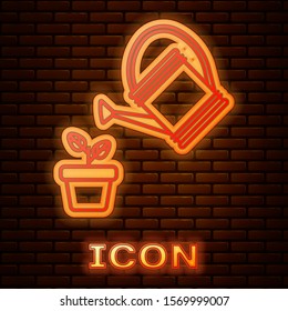 Glowing neon Watering can sprays water drops above plant in pot icon isolated on brick wall background. Irrigation symbol.  Vector Illustration