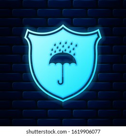 Glowing neon Waterproof icon isolated on brick wall background. Shield and umbrella. Protection, safety, security concept. Water resistant symbol.  Vector Illustration