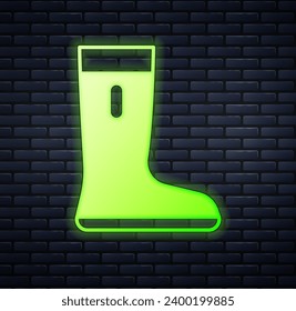 Glowing neon Waterproof rubber boot icon isolated on brick wall background. Gumboots for rainy weather, fishing, gardening.  Vector