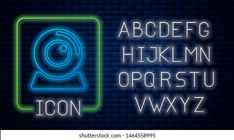 Glowing neon Web camera icon isolated on brick wall background. Chat camera. Webcam icon. Neon light alphabet. Vector Illustration