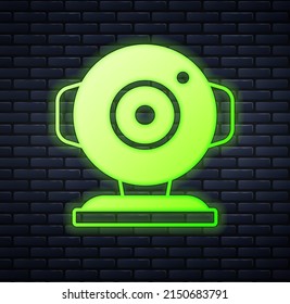 Glowing neon Web camera icon isolated on brick wall background. Chat camera. Webcam icon.  Vector
