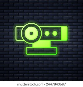 Glowing neon Web camera icon isolated on brick wall background. Chat camera. Webcam icon.  Vector