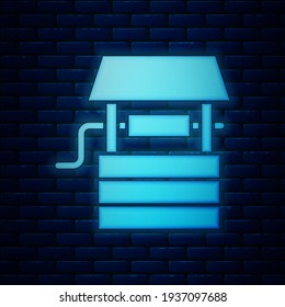Glowing neon Well with a bucket and drinking water icon isolated on brick wall background.  Vector