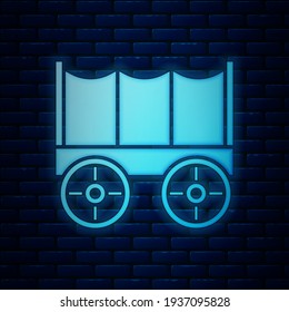 Glowing Neon Wild West Covered Wagon Icon Isolated On Brick Wall Background.  Vector