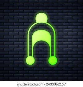 Glowing neon Winter hat icon isolated on brick wall background.  Vector