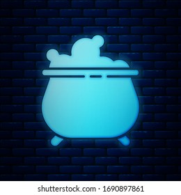 Glowing neon Witch cauldron icon isolated on brick wall background. Happy Halloween party.  Vector Illustration