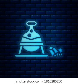 Caldera de neón brillante y icono de piedra mágica aislado en un fondo de pared de ladrillo.  Ilustración vectorial
