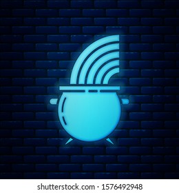Glowing neon Witch cauldron and rainbow icon isolated on brick wall background. Happy Saint Patricks day.  Vector Illustration