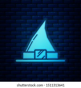 Glowing neon Witch hat icon isolated on brick wall background. Happy Halloween party.  Vector Illustration