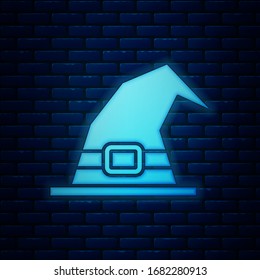 Glowing neon Witch hat icon isolated on brick wall background. Happy Halloween party.  Vector Illustration