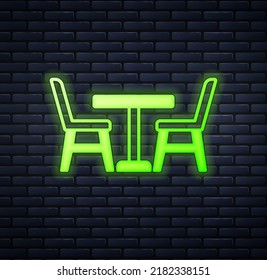 Glowing neon Wooden table with chair icon isolated on brick wall background.  Vector