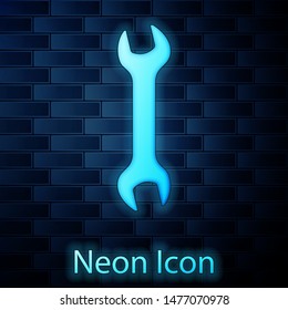 Glowing neon Wrench icon isolated on brick wall background. Spanner repair tool. Service tool symbol.  Vector Illustration