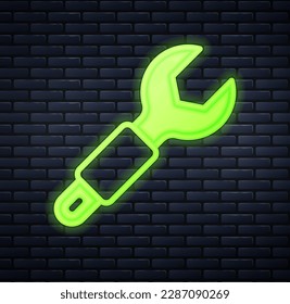 Glowing neon Wrench spanner icon isolated on brick wall background. Spanner repair tool. Service tool symbol.  Vector